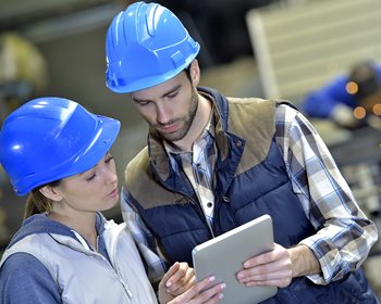 Coworkers read data to gain advantages of statistical quality control on a manufacturing production line